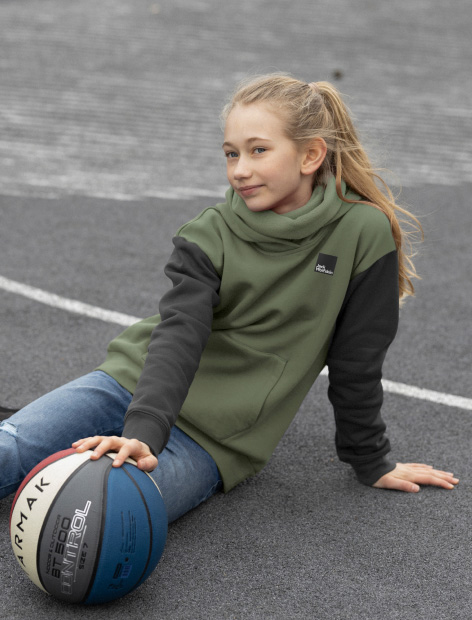 Dziewczyna siedzi na podłodze z piłką do koszykówki