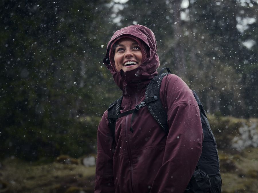 Kobieta w kurtce przeciwdeszczowej w deszczu w lesie
