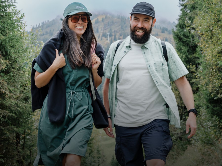 Troje młodych ludzi w sportowym ubraniu outdoorowym trzyma się na tle górskiego&nbsp;krajobrazu