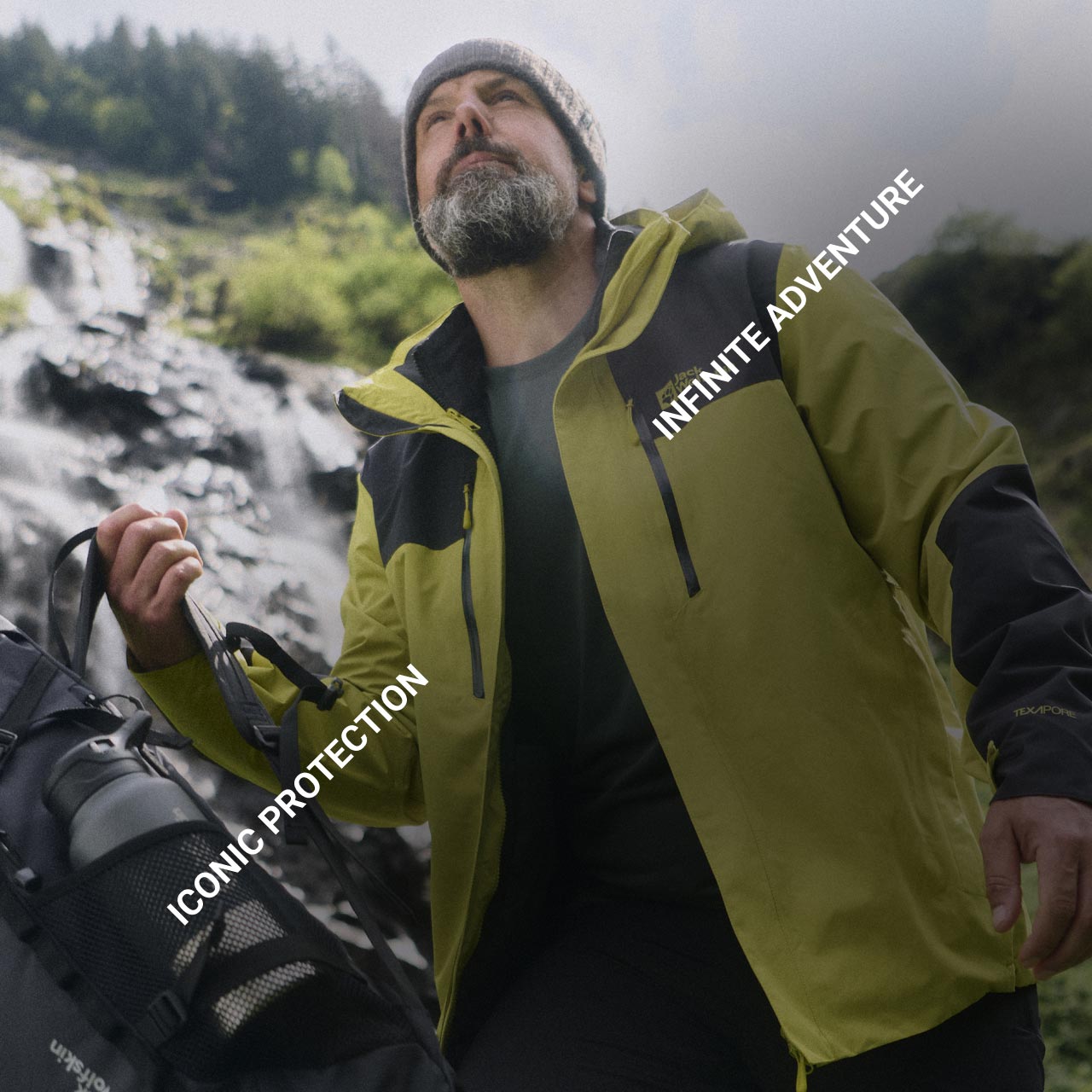 Mężczyzna w żółtej kurtce i beżowej czapce stoi z plecakiem na świeżym powietrzu i patrzy w górę. Tekst brzmi „Iconic Protection” i „Infinite Adventure”