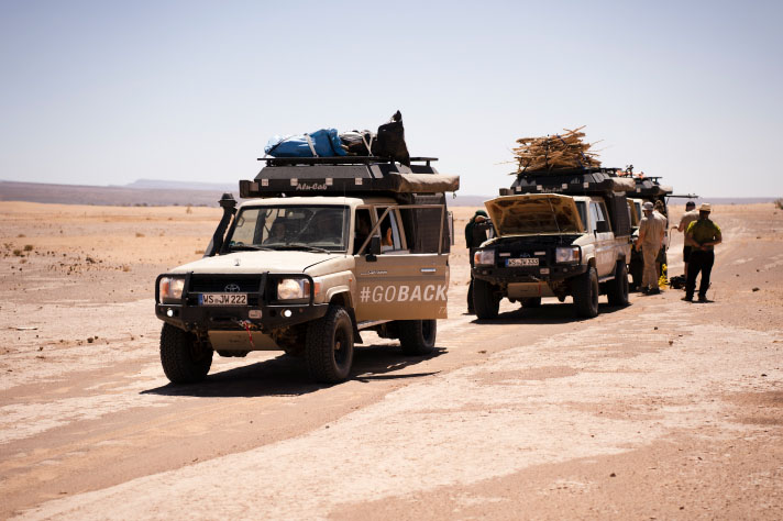 Dwa zapakowane po dach samochody terenowe na pustyni