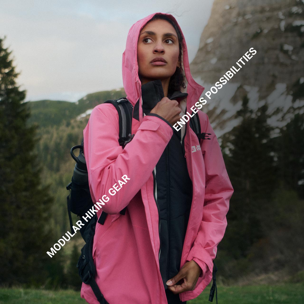Osoba w różowej kurtce stoi na górzystym leśnym terenie i patrzy w zamyśleniu. Tekst brzmi: „Modular Hiking Gear” i „Endless Possibilities”